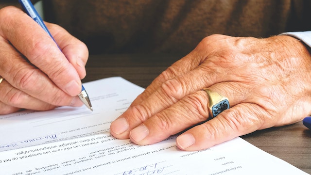 a close up on hands signing a contract