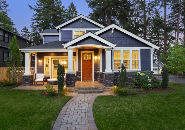 A single family home and investment is pictured in the evening, with blue-grey panelling, white trim and great curb appeal.