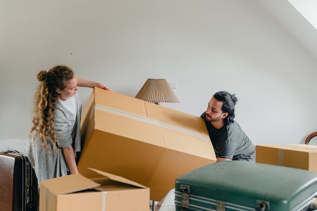 two people moving a large box