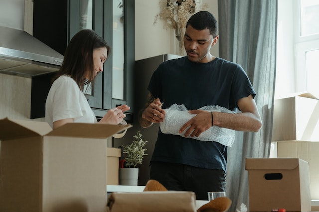  two people packing up belongings in their kitchen